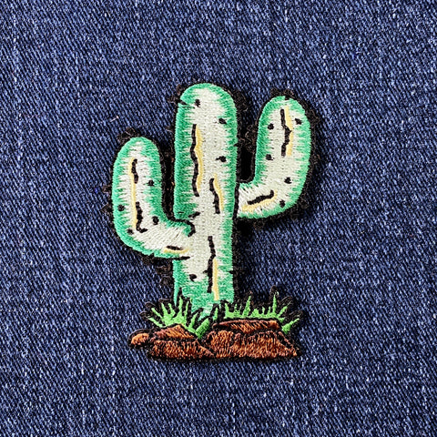 Embroidered cactus patch on a denim background