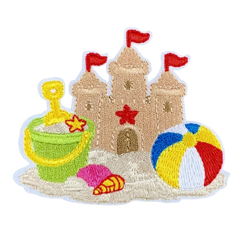 A beach and sandcastle patch which includes a tan sandcastle with red flags, a green bucket, a red star, a pink seashell, and a red, white, blue, and yellow beach ball on a white base.