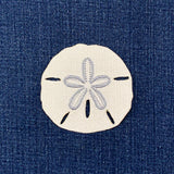 Embroidered sand dollar patch on denim fabric