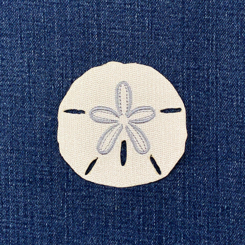 Embroidered sand dollar patch on denim fabric