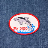 Embroidered patch with a dolphin and 'San Diego' text on denim fabric