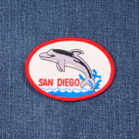 Embroidered patch with a dolphin and 'San Diego' text on denim fabric