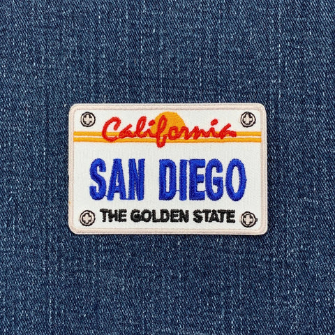 Embroidered patch of a California license plate with 'San Diego' on denim fabric