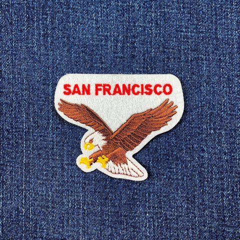 Embroidered patch with an eagle and 'San Francisco' text on denim fabric