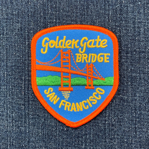 A shield-shaped embroidered patch features the Golden Gate Bridge in orange, with "Golden Gate BRIDGE" and "SAN FRANCISCO" text.