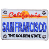 An embroidered rectangular patch styled like a vintage California license plate, with 'California' in red script over a yellow-orange sun and stripes, 'SAN FRANCISCO' in large blue letters, and 'THE GOLDEN STATE' in black text on a white background.