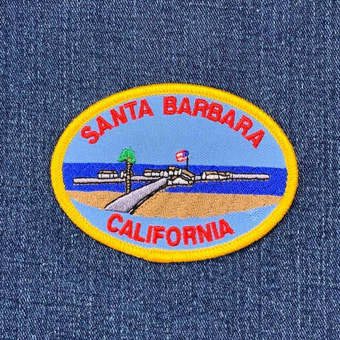 An oval-shaped patch featuring the text 'Santa Barbara California' with an illustration of a beach and pier. 