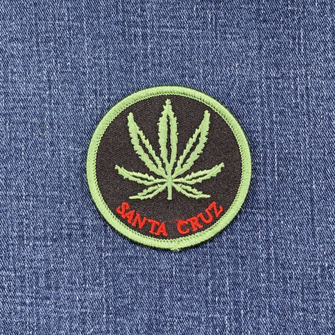 Embroidered patch with a cannabis leaf and 'Santa Cruz' text on denim fabric