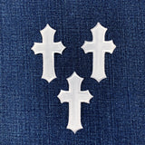 3 white cross patches on a denim background