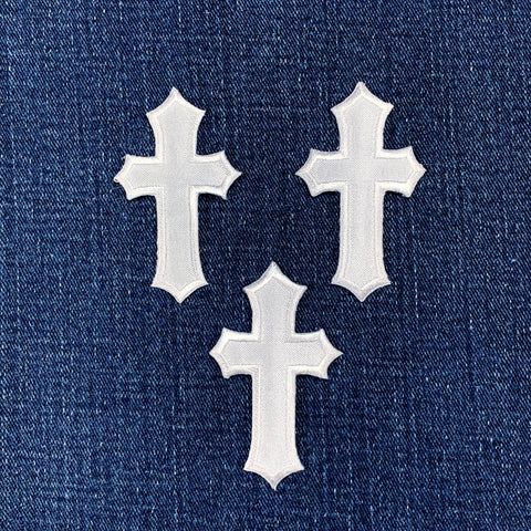 3 white cross patches on a denim background