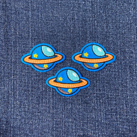 Three planet-shaped patches on a denim background
