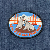 Embroidered patch with two seals and a bridge on denim fabric
