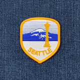 Embroidered patch of Seattle with Space Needle and Mount Rainier on denim fabric