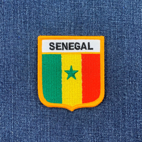 Embroidered patch with Senegal flag design on a blue denim background