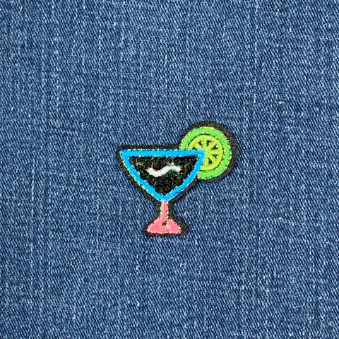 Embroidered patch of a cocktail with a lime on denim fabric