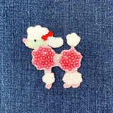Sequined poodle patch with a red bow on denim fabric