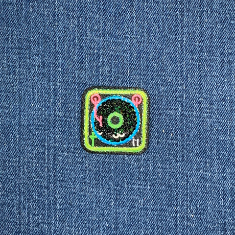 Colorful patch with a record player design on a denim background