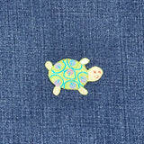 Embroidered turtle patch on denim fabric