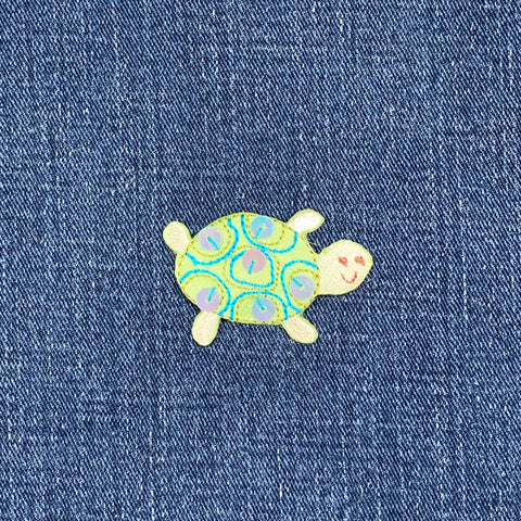 Embroidered turtle patch on denim fabric