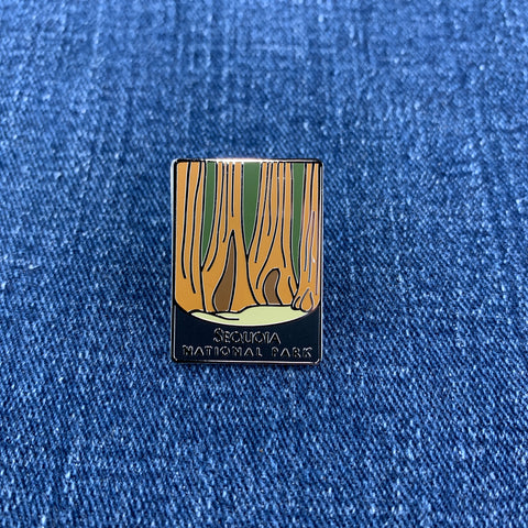 A rectangular enamel pin for Sequoia National Park showing towering orange-brown sequoia trees against a denim background.