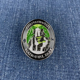 An oval enamel Walking Stick Medallion featuring Shenandoah National Park, displayed on a blue denim background.