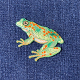 Embroidered frog patch on denim fabric