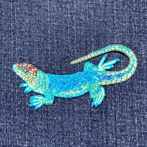 Blue lizard patch on a denim background