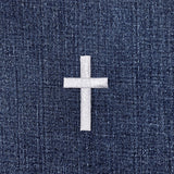 Silver cross patch on a blue denim background