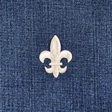 Silver fleur-de-lis patch on a denim background
