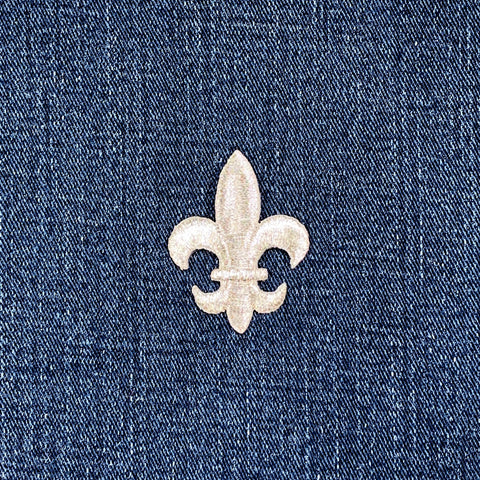 Silver fleur-de-lis patch on a denim background