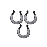 three silver and black horseshoe patches on a denim background