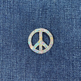 silver peace symbol patch on blue denim fabric