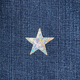 Star-shaped silver sequin patch on a denim fabric background