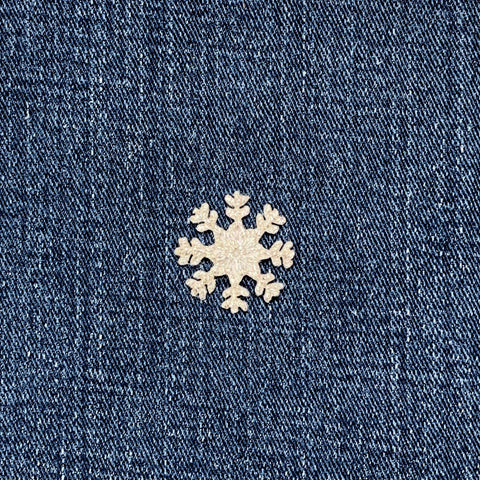 silver snowflake patch on a denim background