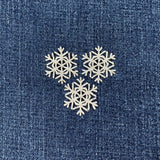 Three snowflake patches on a denim background