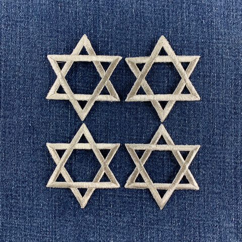 4 silver star of David patches on a denim background