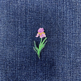 Embroidered iris flower patch on denim fabric