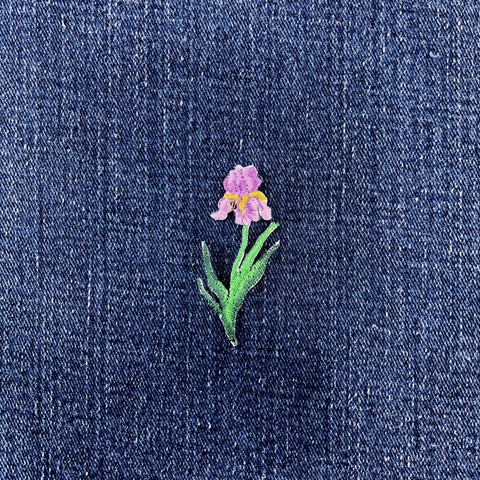 Embroidered iris flower patch on denim fabric
