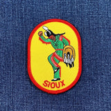 Colorful patch with a dancing figure and 'Sioux' text on a blue denim background