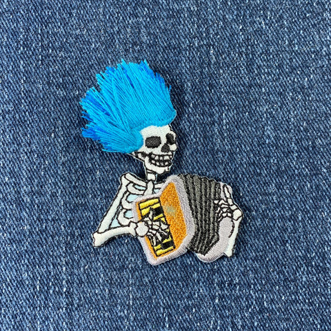 Skeleton with blue hair playing an accordion on denim fabric