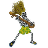 Embroidered patch depicting a dancing skeleton wearing yellow and green patterned shorts and blue flip-flops. The skeleton has a spiked blond/khaki hairdo made of loose thread and is playing a brown stringed instrument