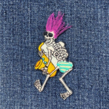 Embroidered patch depicting a walking skeleton playing a yellow saxophone wearing sunglasses, a spiked purple hairdo made of loose thread, and blue and yellow striped shorts, displayed on a denim background