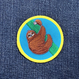 Embroidered patch of a sloth on denim fabric