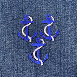 Three blue anchor patches with white rope on a denim background