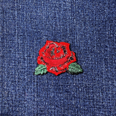 Red rose patch on blue denim fabric