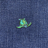 Colorful turtle patch on a denim fabric background