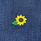 Yellow sunflower patch on blue denim fabric