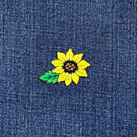 Yellow sunflower patch on blue denim fabric