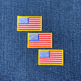 Three American flag patches on a denim background