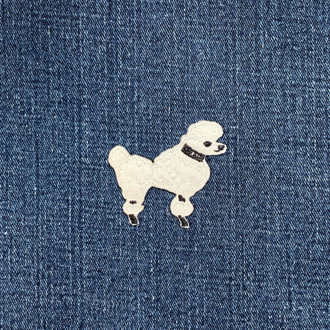 White poodle patch on blue denim fabric